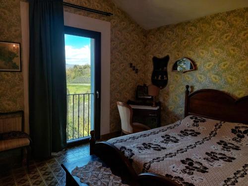 a bedroom with a bed and a window with a balcony at La Casa di Cesarina in Celle sul Rigo