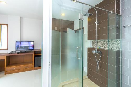 a bathroom with a glass shower with a computer on a desk at Baan Lukkan Patong Resort in Patong Beach