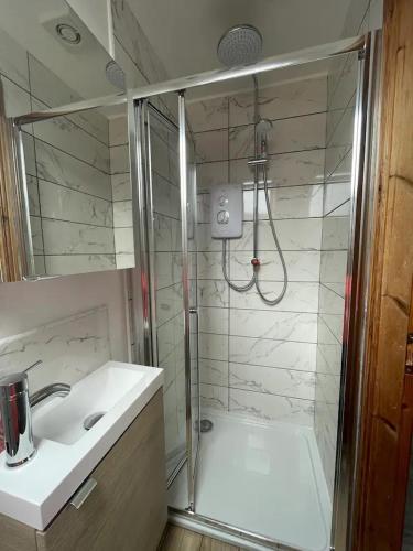 a bathroom with a shower and a sink at Wind Rose Rooms in Ballycastle