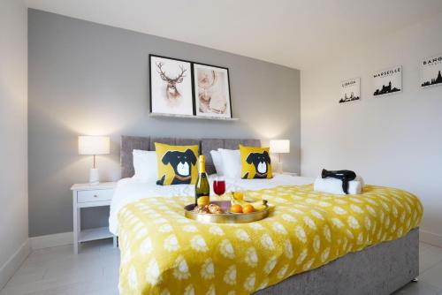 a bedroom with a bed with a bowl of fruit on it at Stylish 6 Bedroom 3 Bathroom Detached House with Free Parking, Super-Fast Wifi, Pool Table, Smart TVs with Netflix by Yoko Property in Milton Keynes