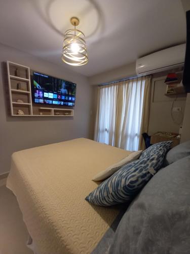 1 dormitorio con 1 cama y TV en la pared en Zafiro Barrio Norte by Citrino Aparts en San Miguel de Tucumán