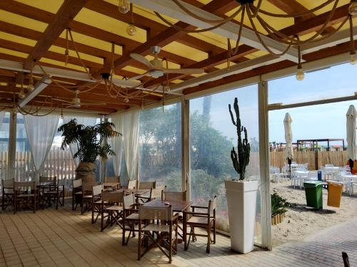 een eetkamer met tafels, stoelen en ramen bij Appartamenti Bellavista 107 in Chioggia