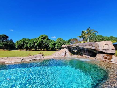 uma grande piscina de água com cascata em Benka LifeStyle Country Cottages em Ezulwini