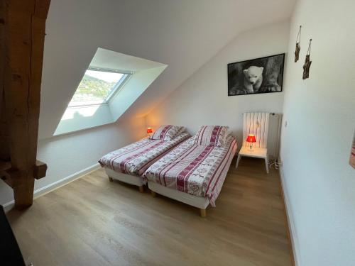 a attic bedroom with a bed and a window at L'Ourson in Gérardmer