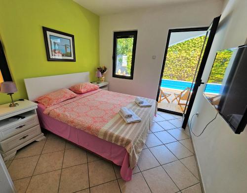 a bedroom with a bed with a television and a balcony at Klaris Guest house in Budva