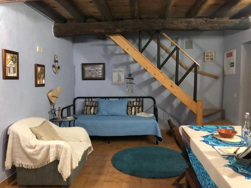 a bedroom with a blue bed and a staircase at Casal dos Carpinteiros - Carpenters Couple in Silveira
