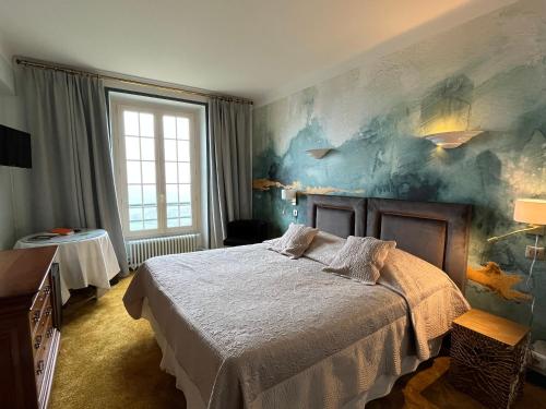 een slaapkamer met een bed en een schilderij aan de muur bij L'Esplanade in Domme