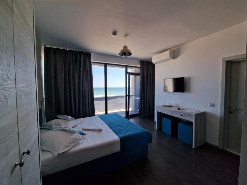 a bedroom with a bed with a view of the ocean at Hotel H in Eforie Nord