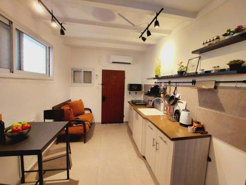 - une cuisine et un salon avec un comptoir et une table dans l'établissement דירת גן בהורקנוס, à Beer-Sheva