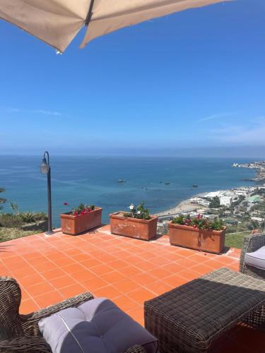 patio con sedie e vista sull'oceano di Villa la Dimora di Zoè a Ischia
