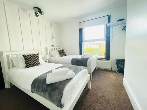 a bedroom with two beds and a window at Lovely Dog Friendly, 3 Bed Home Sleeps 8, with Parking & Fenced Garden WORK CONTRACTOR LEISURE, JASPER in Cambridge
