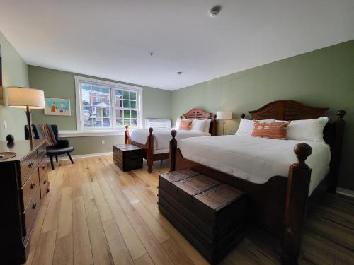 a bedroom with a large bed and a desk and chair at The Stowe Village Inn in Stowe