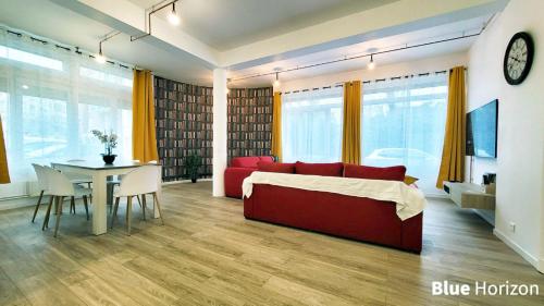 un salon avec un canapé rouge et une table dans l'établissement Le Nautilus - Plage et Kursaal, à Dunkerque