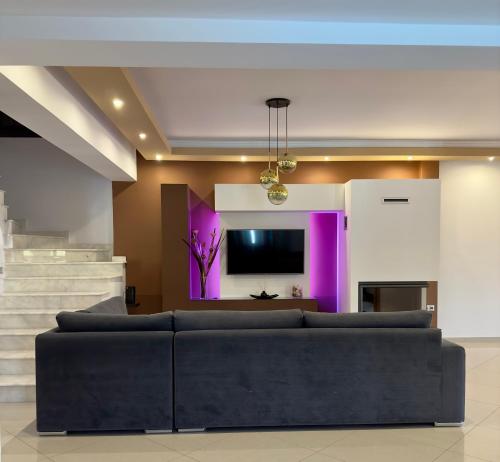 a living room with a couch and a tv at Villa Rose Ground Floor - Private Swimming Pool Garden in Koskinou