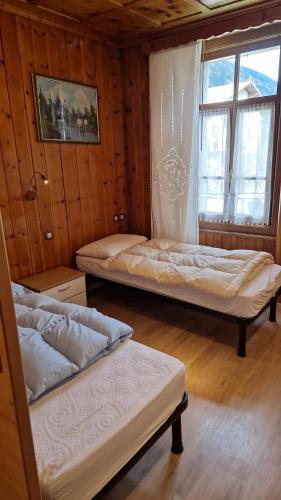 1 dormitorio con 2 camas y ventana. en Casa Alberti, en Valfurva