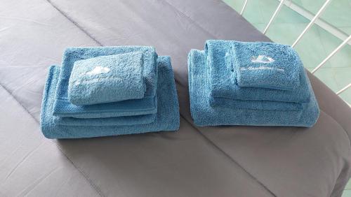 duas toalhas azuis sentadas em cima de uma cama em La Casetta nel Bosco em Ischia
