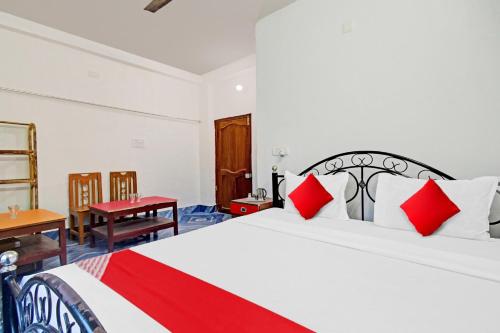 een slaapkamer met een groot wit bed met rode kussens bij Flagship D.M.2 Resort in Bāgnān
