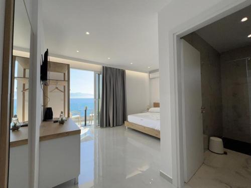 a bedroom with a bed and a view of the ocean at Sea Breeze Villa in Sarandë