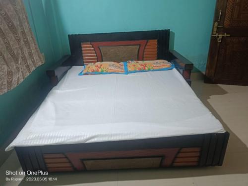 een bed in een slaapkamer met een houten hoofdeinde bij Comfort Inn Kamakhya Jn in Guwahati