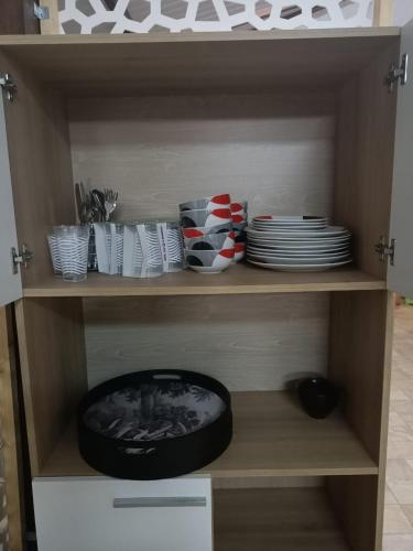 a shelf with plates and bowls and dishes in a kitchen at Les 2 Chambres Wassai in Rémiré