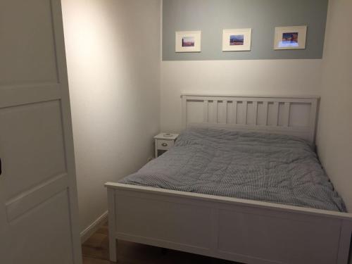 a bed in a bedroom with two pictures on the wall at derankerplatz-fehmarn in Burgtiefe auf Fehmarn 