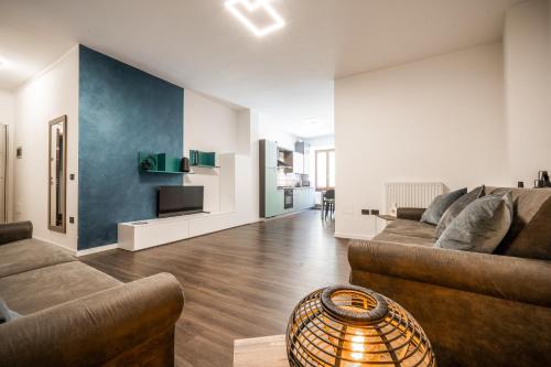 a living room with two couches and a tv at Appartamenti Vasco Renna Surf Center in Nago-Torbole