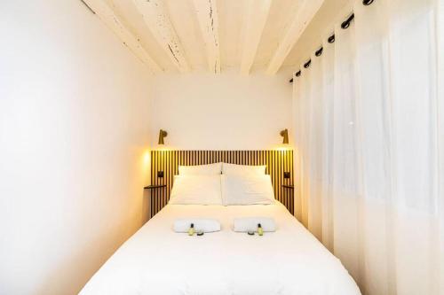 a bedroom with a bed with two white pillows at GuestReady - Wabi-Sabi Minimal in Marais in Paris