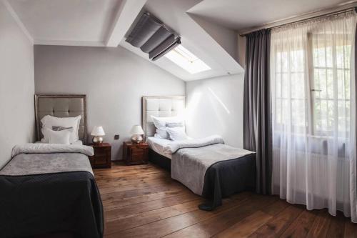 a bedroom with two beds and a window at Constantia by Grape Hotel in Wrocław
