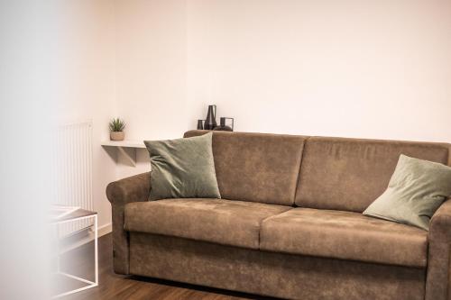 a brown couch sitting in a living room at Appartamenti Vasco Renna Surf Center in Nago-Torbole