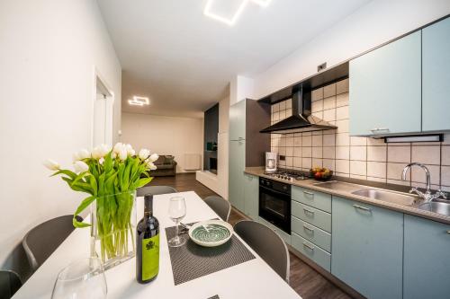 a kitchen with a table with a vase of flowers on it at Appartamenti Vasco Renna Surf Center in Nago-Torbole