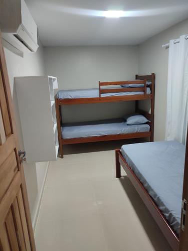 a small room with two bunk beds and a door at JR Casa Contêiners in Boa Vista