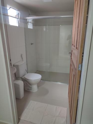 a white bathroom with a toilet and a shower at JR Casa Contêiners in Boa Vista