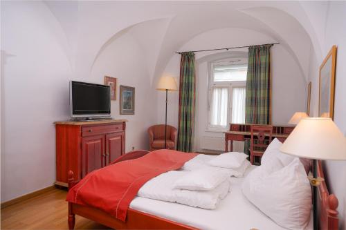 um quarto com uma cama com um cobertor vermelho em Gasthof zum Greif em Leoben