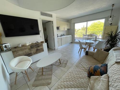a living room with a couch and a table with chairs at Côte d’Azur- Appartement Les Suites de Robinson in Mandelieu-la-Napoule