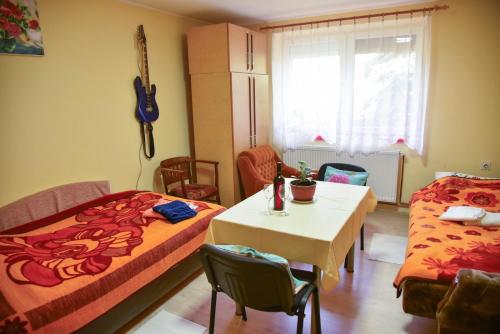 a small room with two beds and a table and a tableablish at sobe MAŠA in Subotica