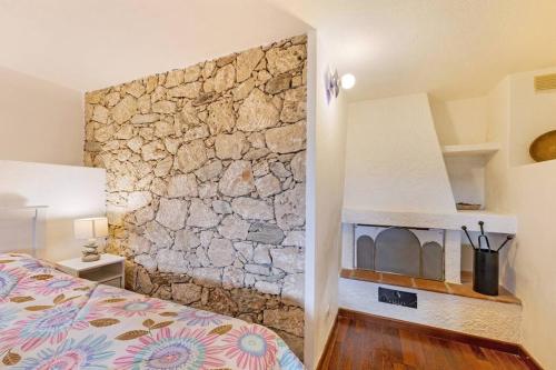 a bedroom with a stone wall next to a bed at Al 37 vista mare e colline in Finale Ligure