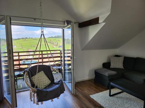 a swing in a living room with a balcony at Apartament u Ewki in Rdzawka