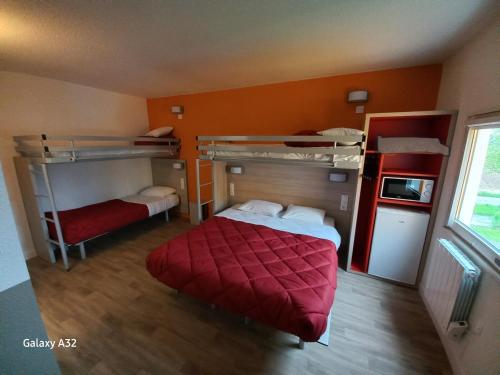 OrmoyにあるPremiere Classe Evry Sud - Mennecyの二段ベッド2組と赤い毛布が備わる客室です。