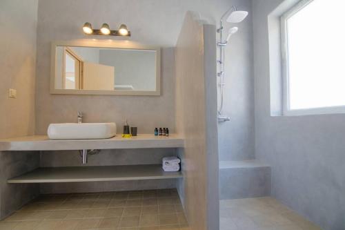 a bathroom with a sink and a mirror at Sea and Sun l in Mylopotas