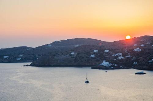 a boat in the water with the sunset in the background at Sea and Sun l in Mylopotas