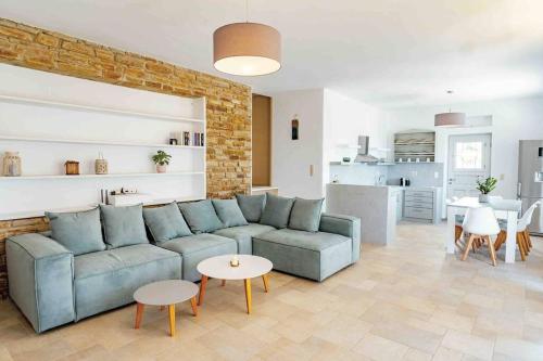 a living room with a blue couch and a kitchen at Sea and Sun l in Mylopotas