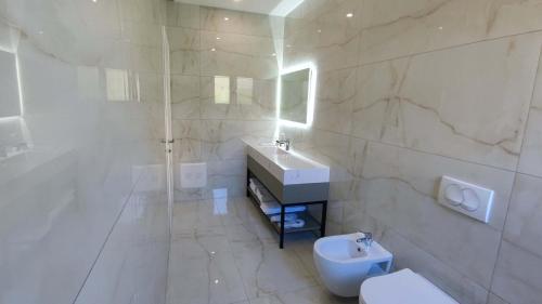 a white bathroom with a sink and a toilet at Hilal Palace - Halal in Golem