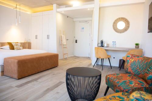 um quarto com uma cama, uma mesa e cadeiras em Grand Hôtel Du Lido em Argelès-sur-Mer