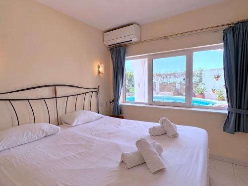 1 dormitorio con 1 cama blanca y 2 toallas en Chimenea 15 Private Pool Casasol, en Nerja