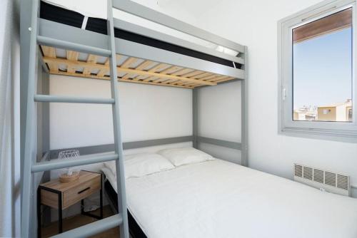 een slaapkamer met 2 stapelbedden en een raam bij Appartement 5 personnes vue mer in Cap d'Agde