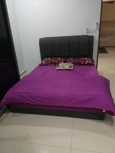 a bed with a purple comforter on top of it at Livin Hub @ Bandar Sri Sendayan in Sendayan Village