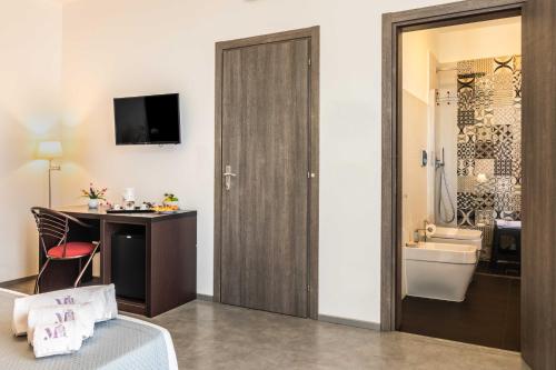 een badkamer met een bed, een bureau en een wastafel bij Marricriu Camere Avola in Avola