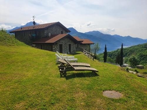a group of benches sitting on a hill in front of a building at Agriturismo Nona Rosa in Gravedona