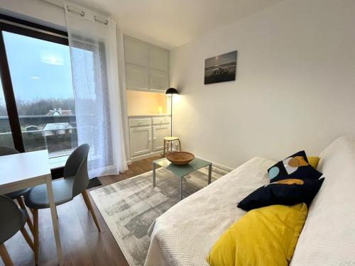 sala de estar con cama, mesa y ventana en Studio cosy au calme à 5 min de la plage, en Camiers