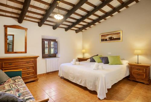 1 dormitorio con 1 cama blanca grande en una habitación en El Mas Pla, en Caldes de Malavella